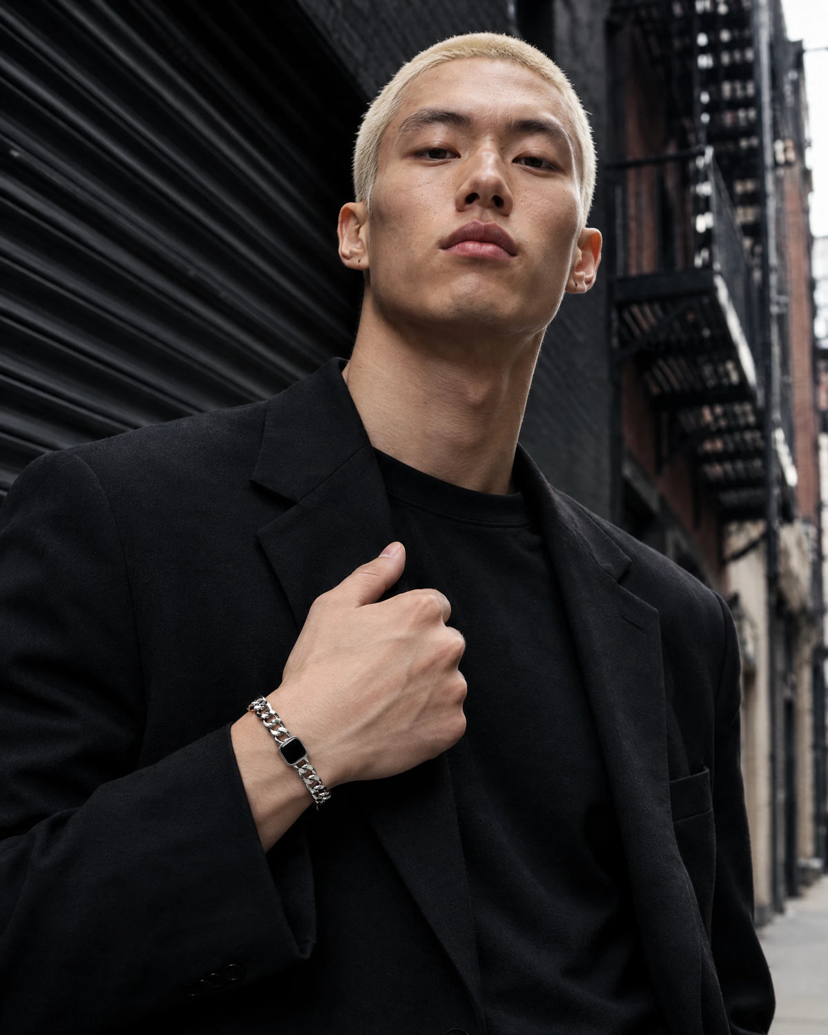 Minos jewelry worn by a model in black streetwear.