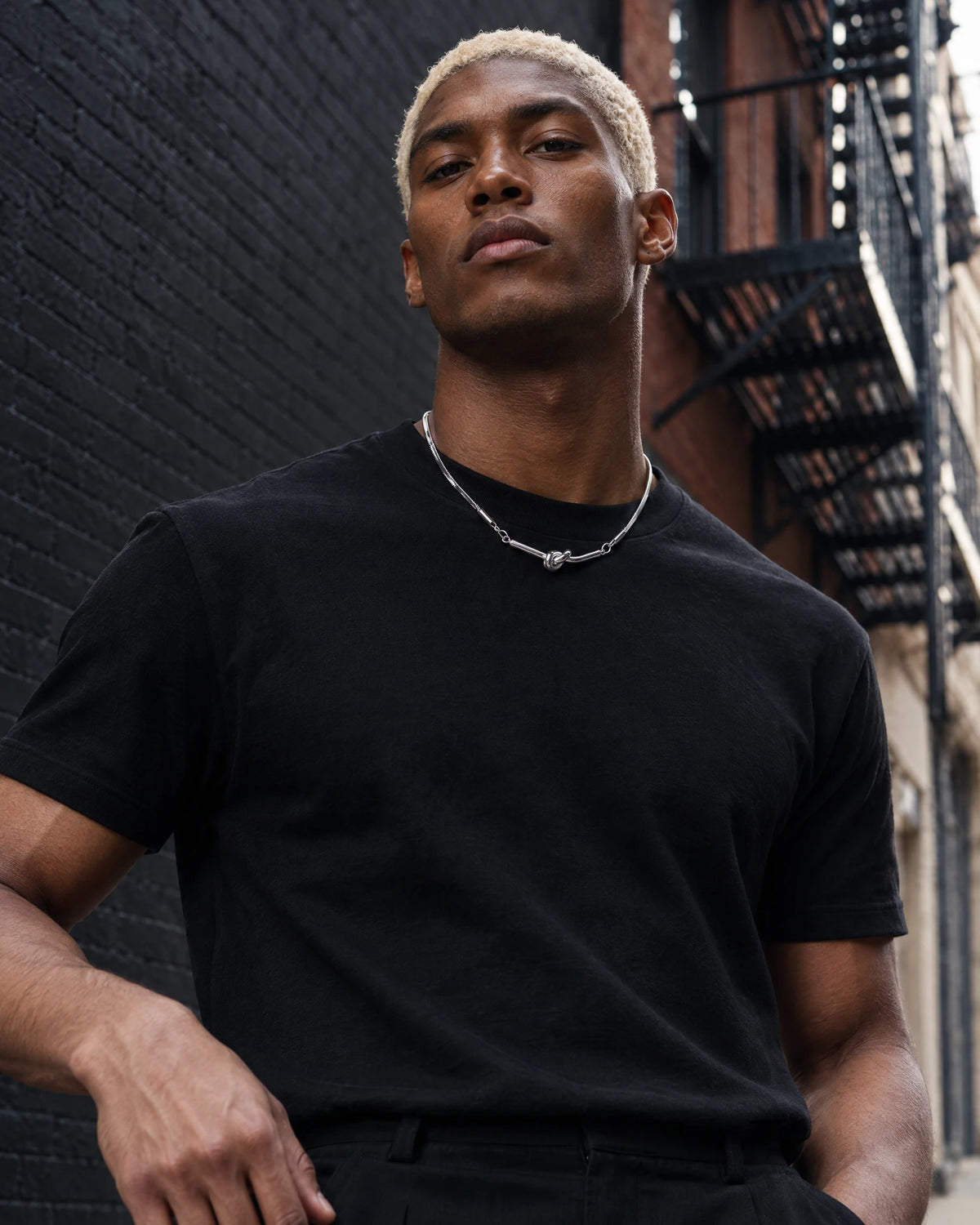 Ophion jewelry worn by a model in black streetwear.