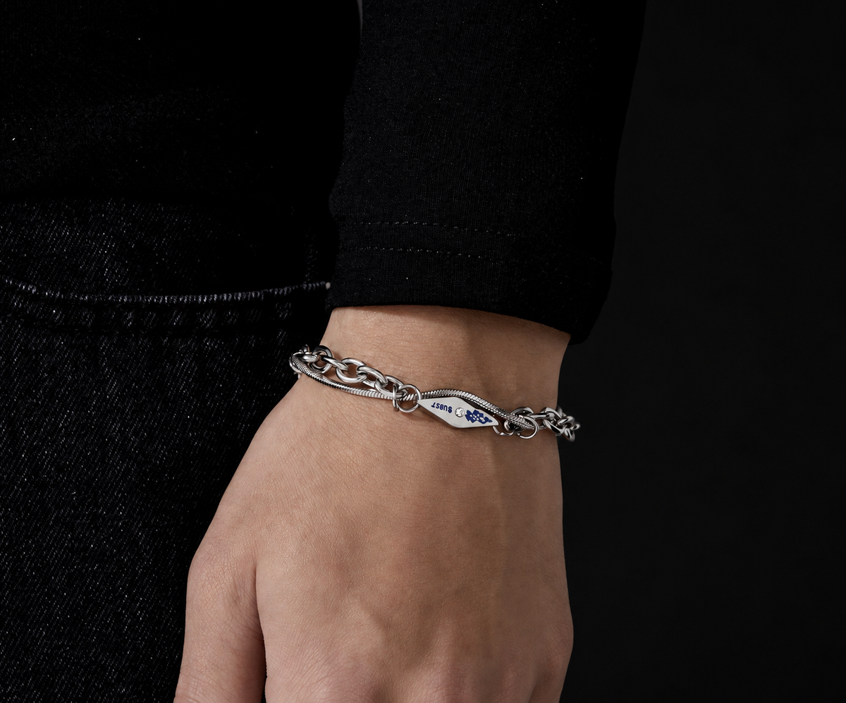 Vulcan sterling silver chain bracelet with blue engraved centre link, on wrist