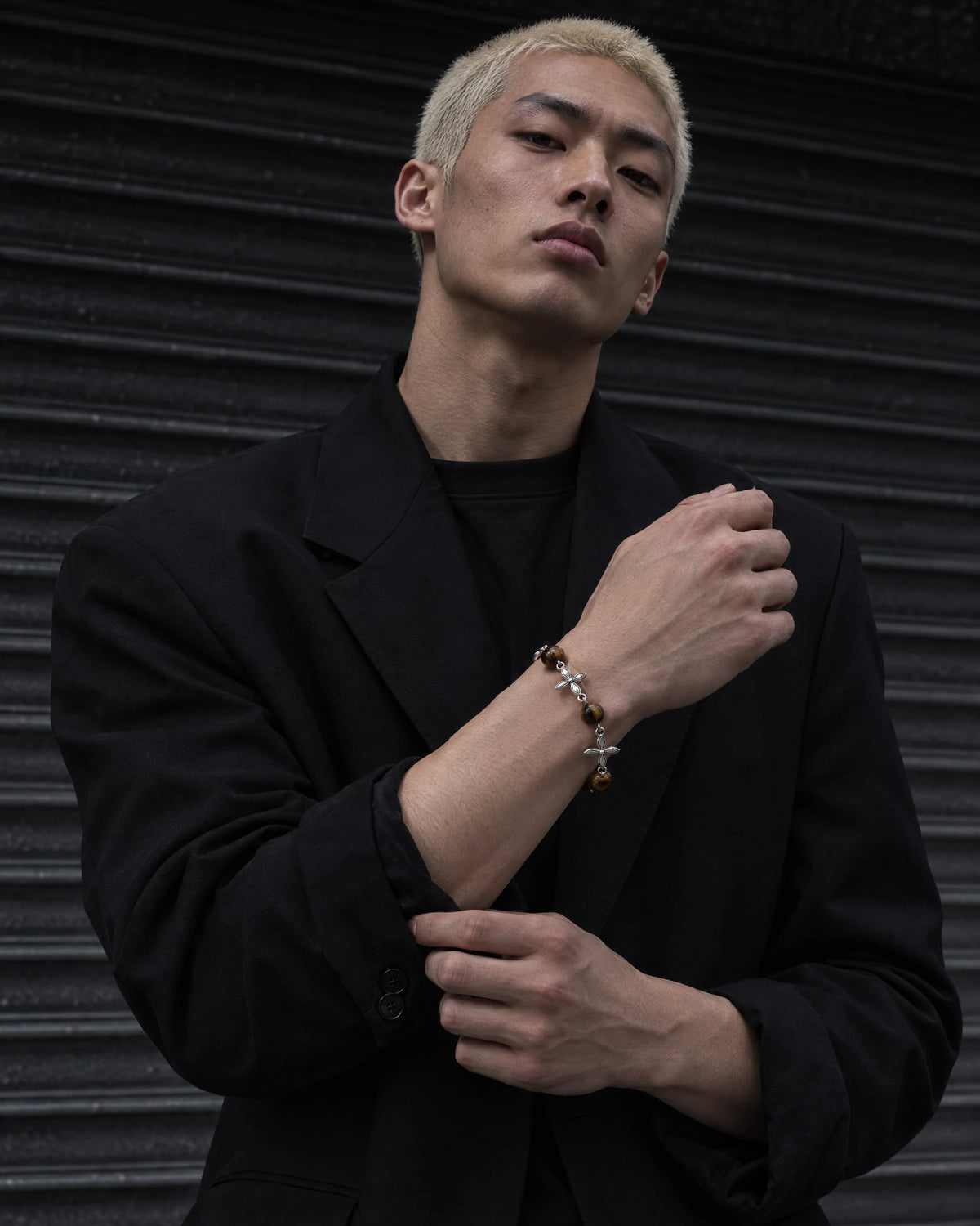 Argus jewelry worn by a model in black streetwear.
