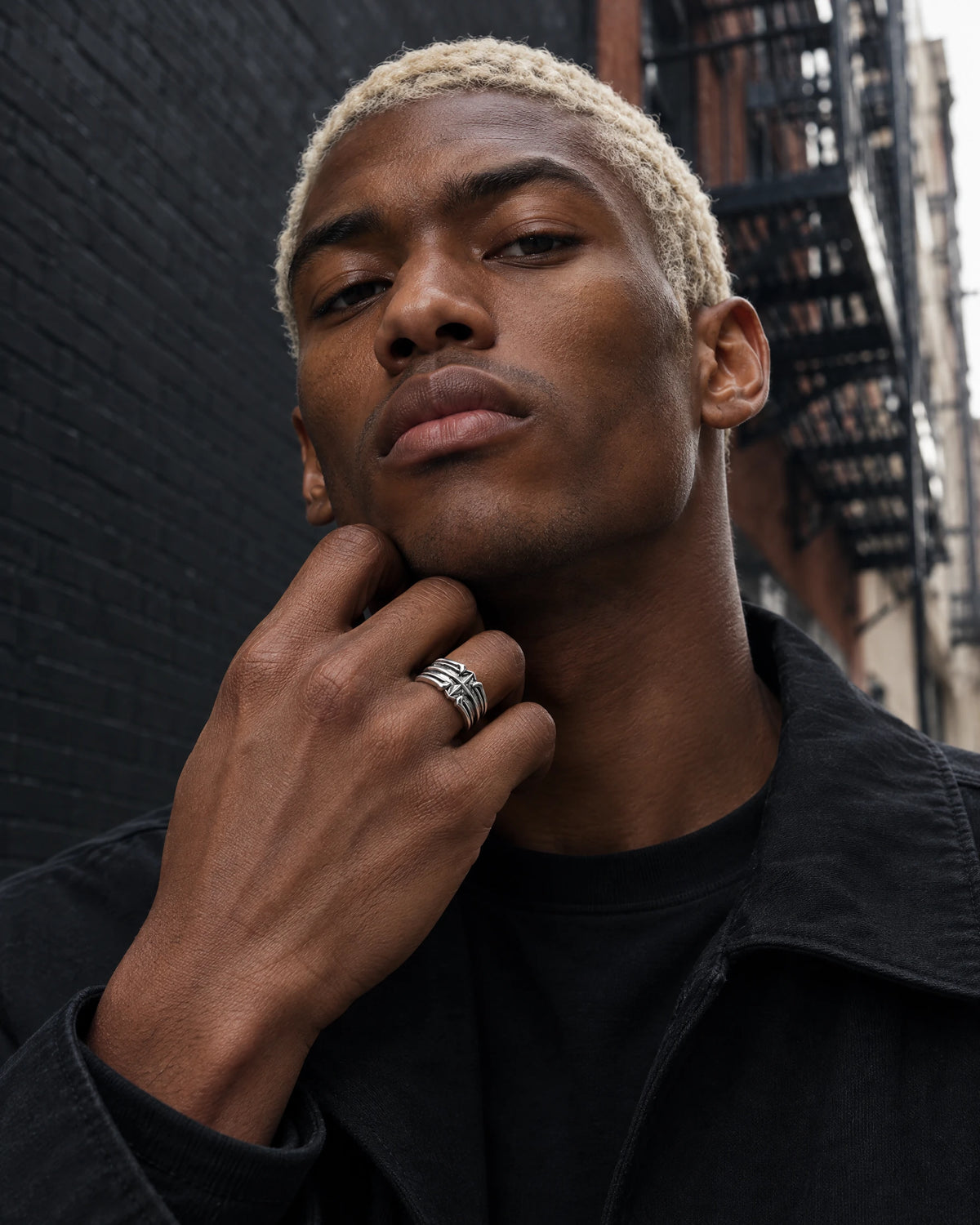 Asterion jewelry worn by a model in black streetwear.