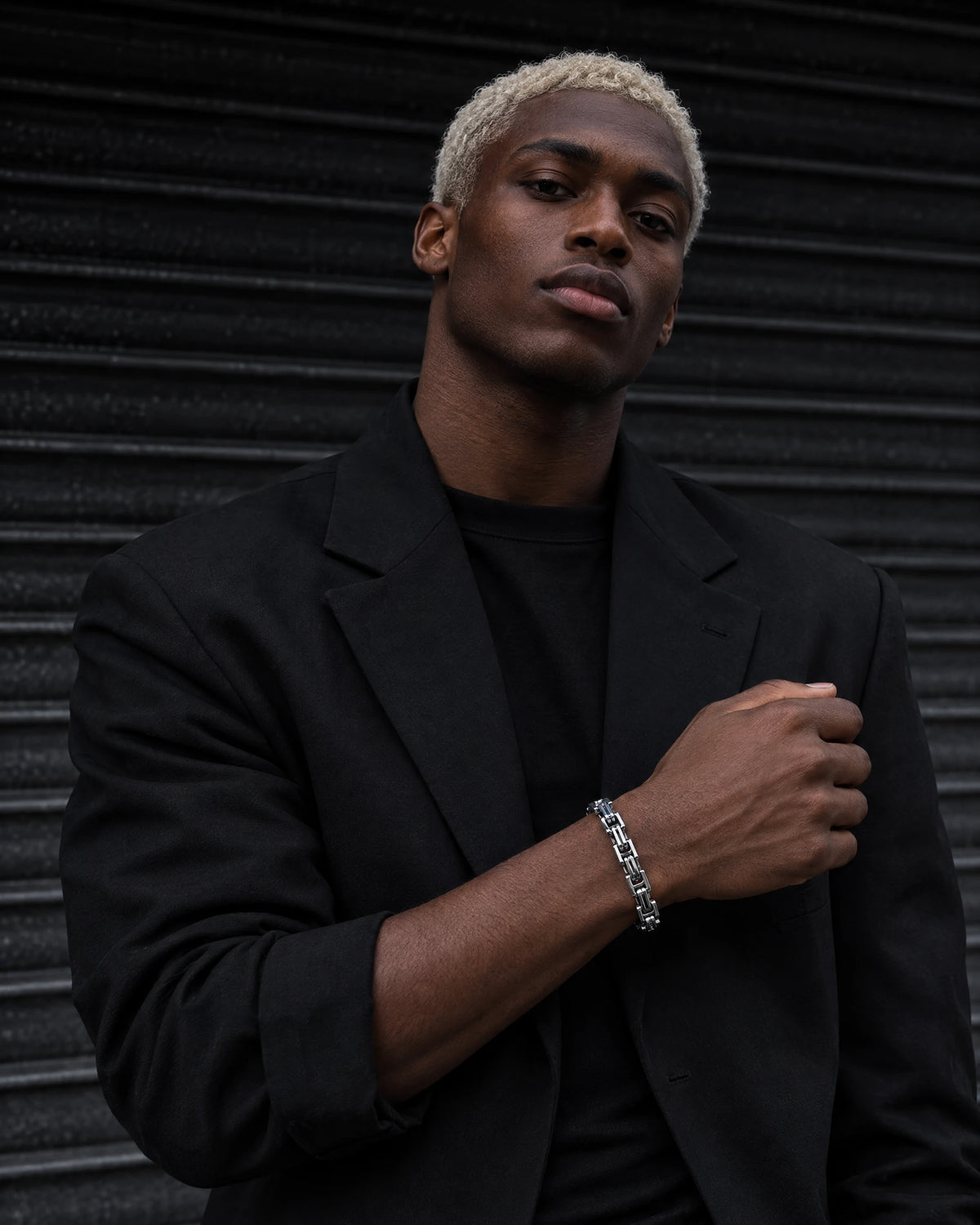 Cerberus jewelry worn by a model in black streetwear.