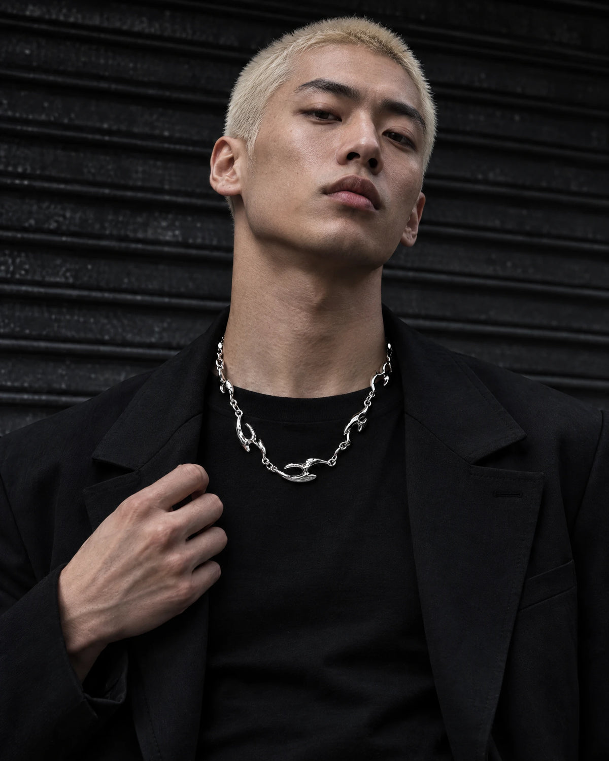 Erebus jewelry worn by a model in black streetwear.
