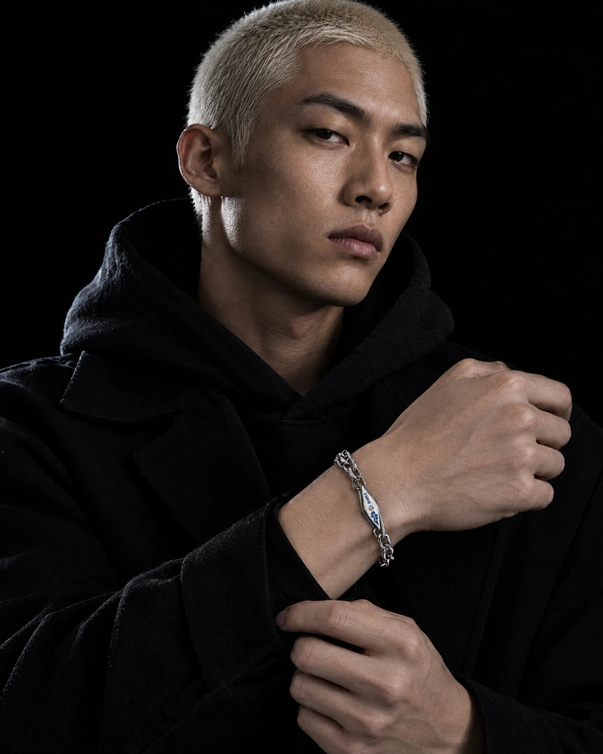 Vulcan jewelry worn by a model in black streetwear.