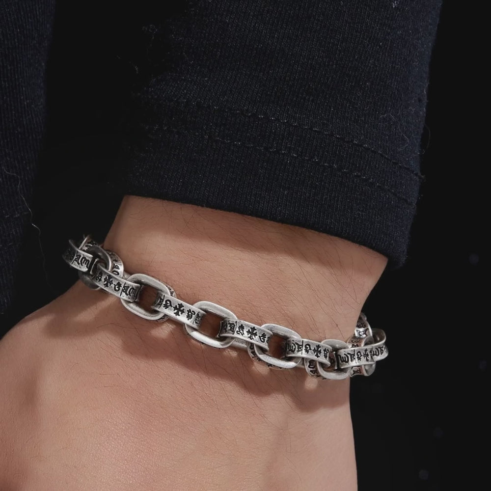 Pluto 925 silver bracelet on the wrist, engraved cross and script links, slow showcase